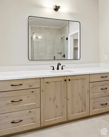 Custom wood-finish vanity with ample storage, integrated rectangular sink, and stone-look countertop