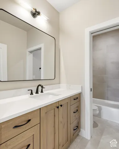 Wood-finish vanity with a white countertop and integrated sink, matte black faucet, and a large rectangular mirror