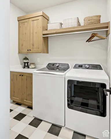 Checkered floor tile, built-in wooden cabinetry, white countertops, built-in wooden shelving, and wall-mounted drying rod