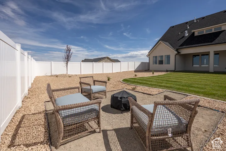 Expansive backyard featuring a manicured lawn, gravel landscaping, and a privacy fence