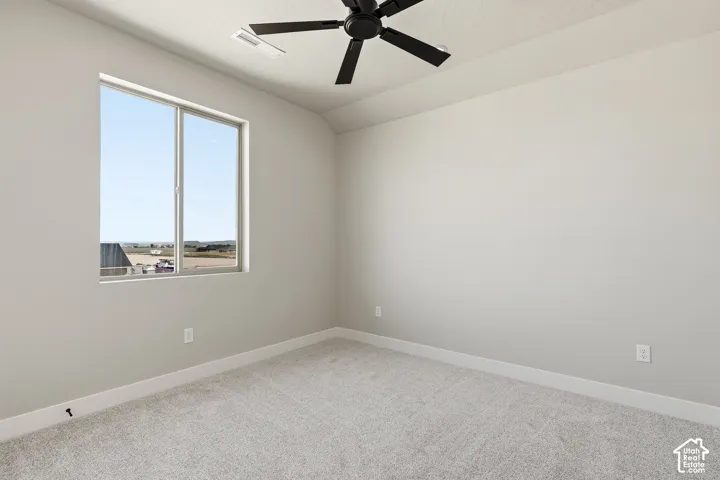 Neutral-toned carpeting and walls, complemented by a contemporary black ceiling fan