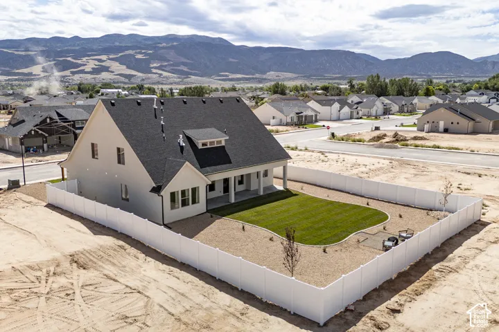 Backyard featuring a manicured lawn, established landscaping, and a white privacy fence