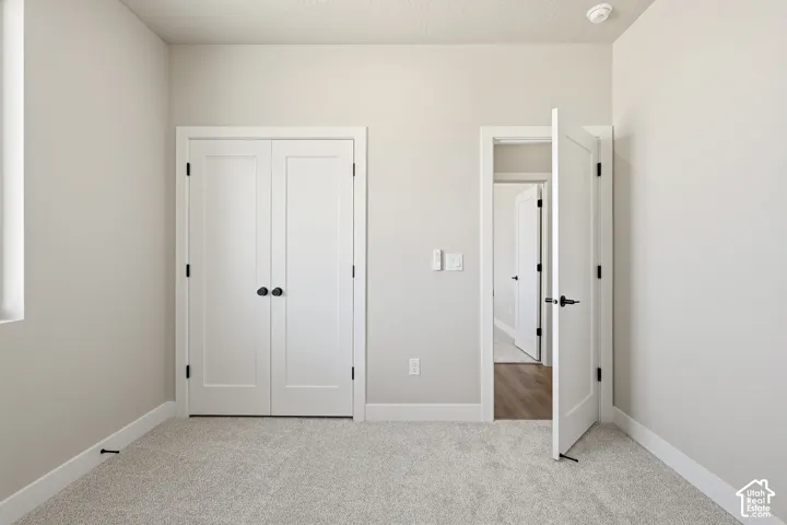 Neutral wall paint, white trim, and light carpeting create a bright interior