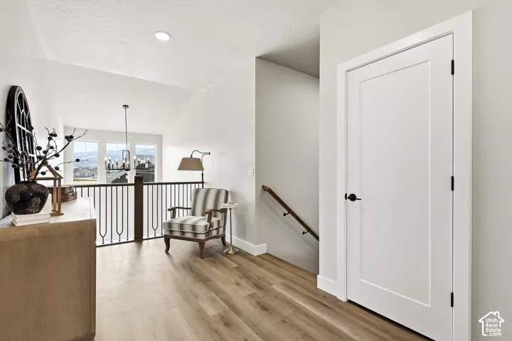 Wood-finish flooring throughout, with a white flat-panel interior door featuring a black knob