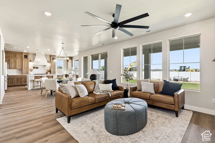 Spacious living area with wood-finish flooring, recessed lighting, and a modern ceiling fan