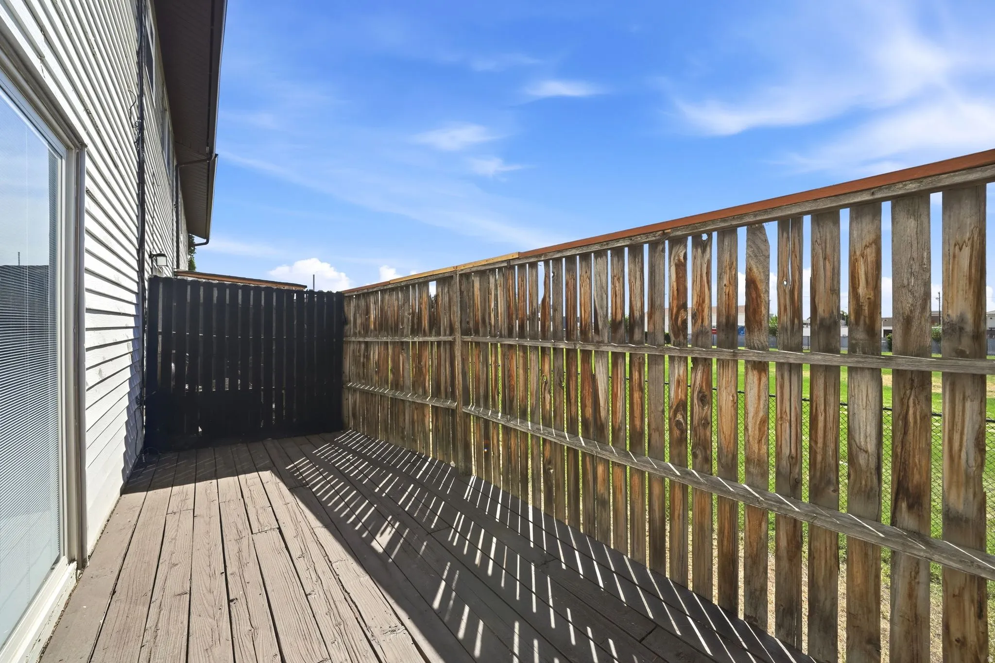Wood-finish decking with a privacy screen and a wood-slat fence