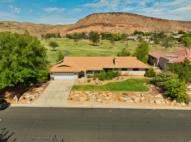 Single-story residence featuring a two-car garage, concrete driveway, and a front lawn with rock landscaping