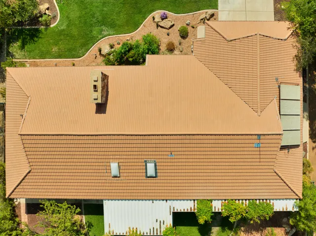 Terracotta tile roof with multiple skylights and a chimney