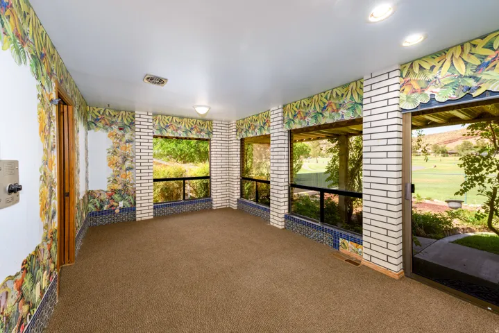 Carpeted interior space with extensive window walls, recessed lighting, and a sliding glass door