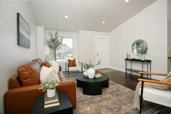 Vaulted ceilings, recessed lighting, dark wood-finish flooring, white paneled door, and a large bay window