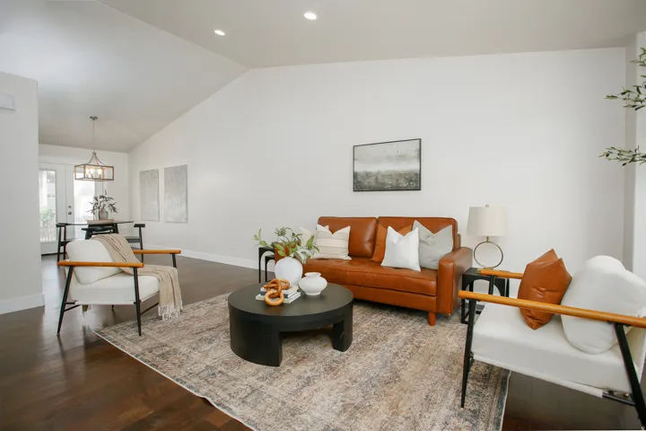 Vaulted ceiling with recessed lighting, dark wood-finish flooring, and white walls