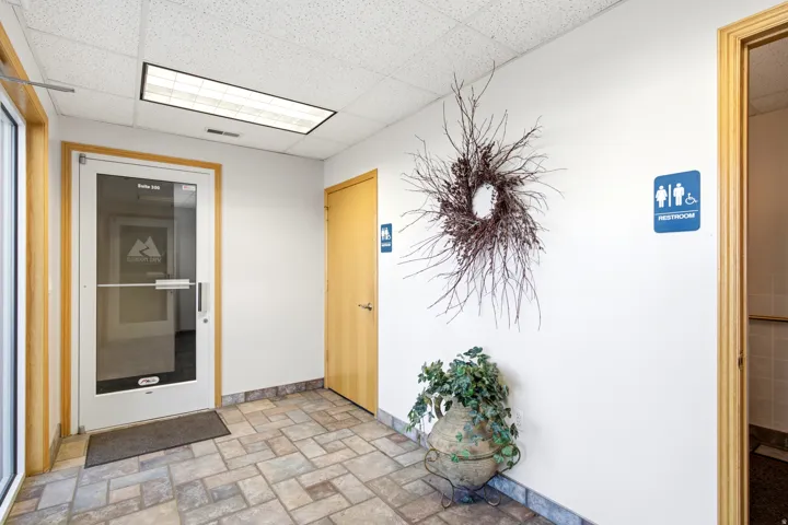 Entry area featuring a glass-paneled door, a solid-core door, a drop ceiling with recessed lighting, and tile flooring