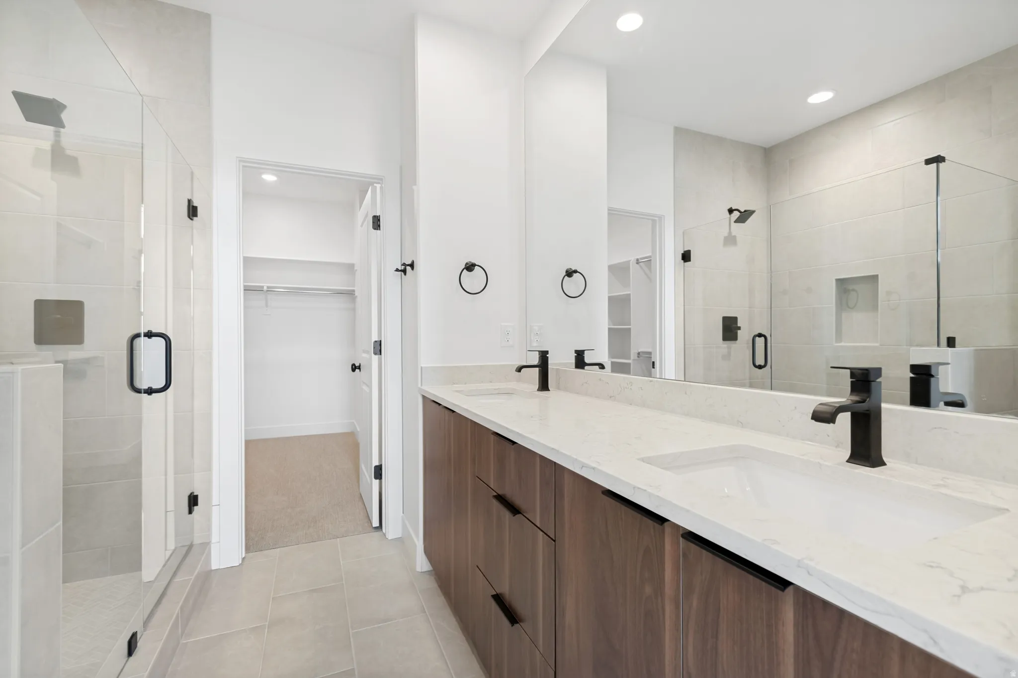 Dual vanity with undermount sinks, stone countertops, and matte black fixtures