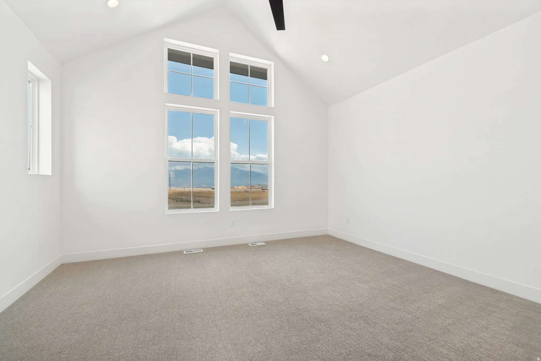 Vaulted ceiling with recessed lighting and a ceiling fan