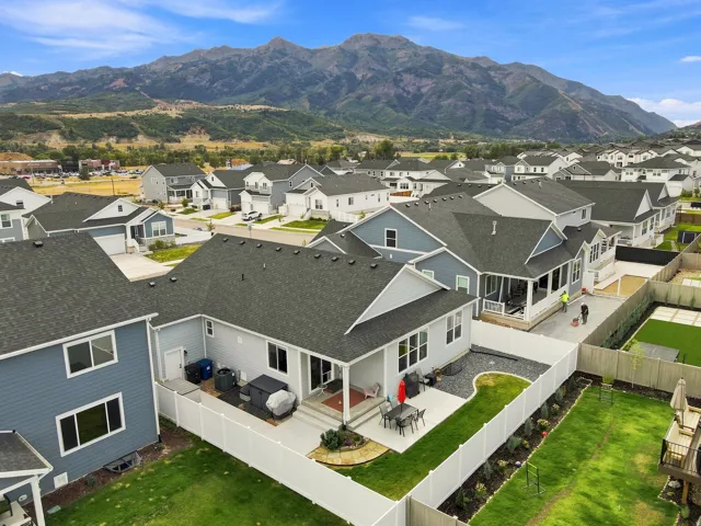 Expansive mountain backdrop, manicured lawn, and a paved patio area