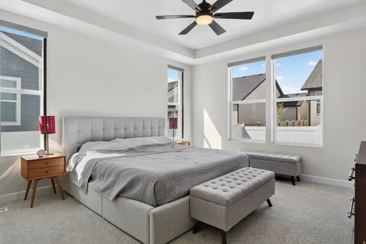 Recessed ceiling with an integrated ceiling fan, multiple tall windows, and light neutral wall paint