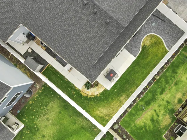 Expansive outdoor spaces featuring a large lawn, concrete walkways, and distinct gravel landscaping elements