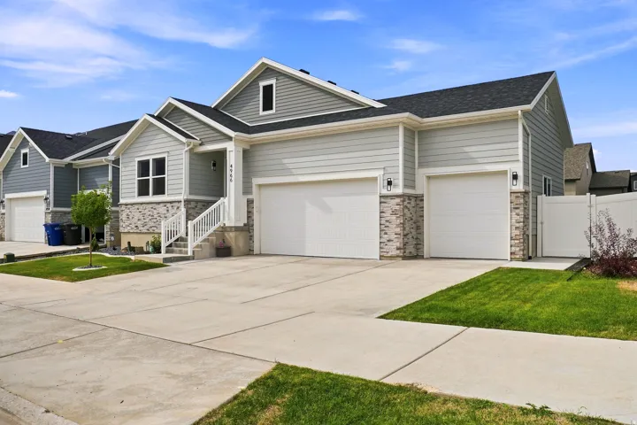 Contemporary exterior featuring light gray siding and stone accents