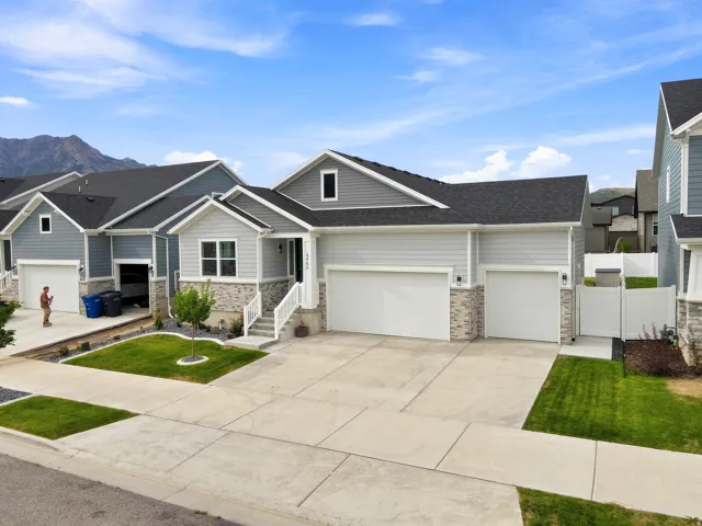 Light gray siding exterior with stone accents and multiple attached garages