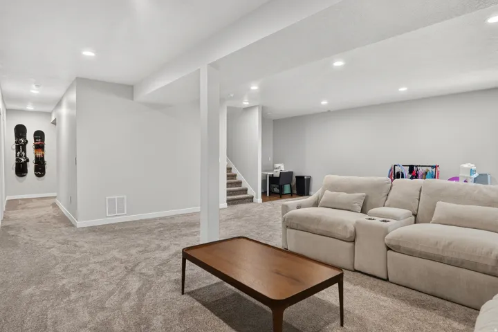 Carpeted flooring throughout, recessed lighting, white trim, and a built-in staircase with carpeted steps