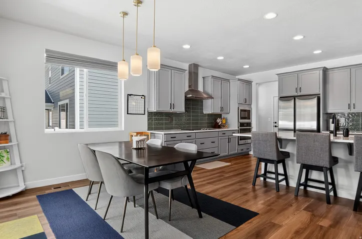 Open-concept kitchen and dining area featuring wood-finish flooring, recessed lighting, and a kitchen island with seating