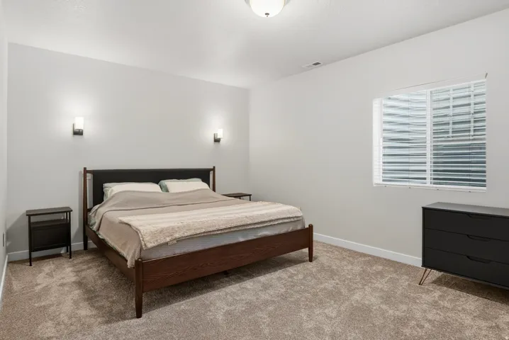 Carpeted flooring, recessed lighting, and wall-mounted sconces