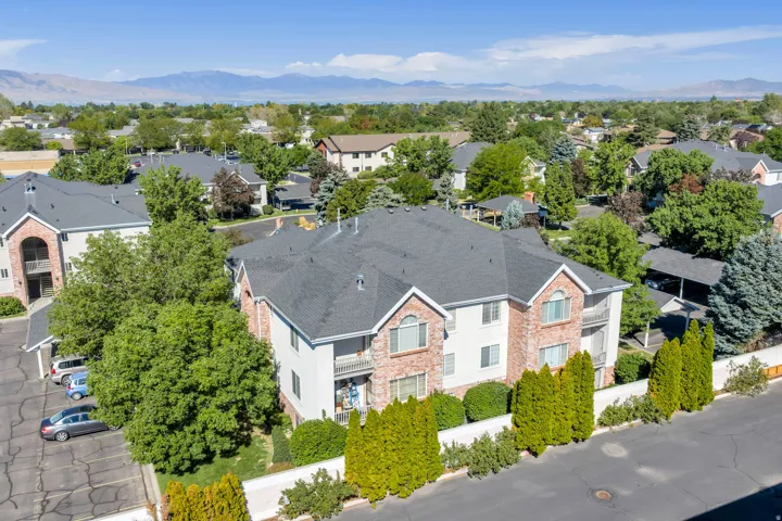 Multi-story building with brick and siding facade, private balconies, and a dark shingle roof