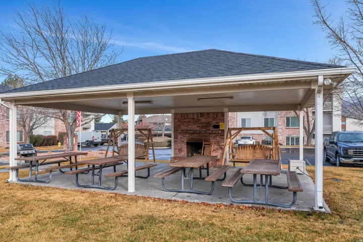 Covered outdoor pavilion has an outdoor fireplace and picnic tables
