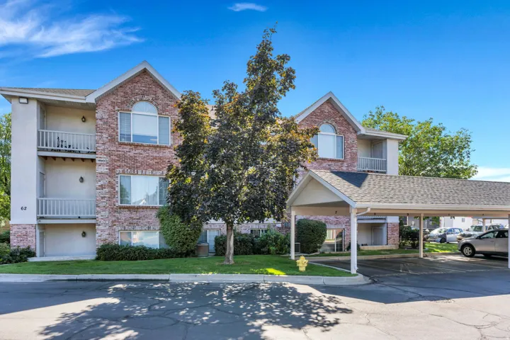 Brick and stucco exterior with multiple balconies, arched window accents, and a covered parking structure