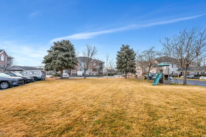 Expansive landscaped grounds featuring mature trees and recreational equipment