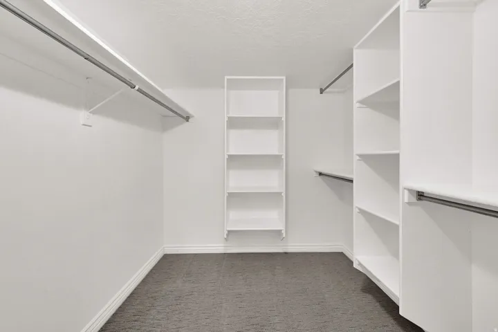 Expansive guest bedroom walk-in closet featuring built-in shelving