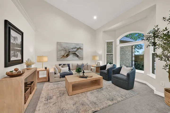 Vaulted ceiling, arched window, recessed lighting, neutral tone walls, and gray carpeting