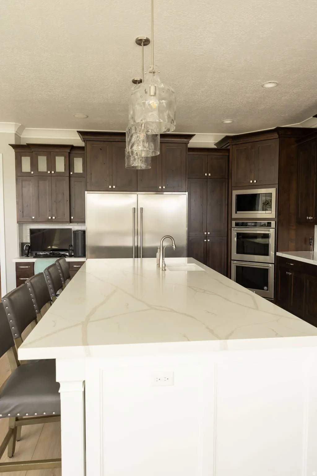 Expansive kitchen island with a light-toned countertop, integrated sink, and brushed nickel faucet