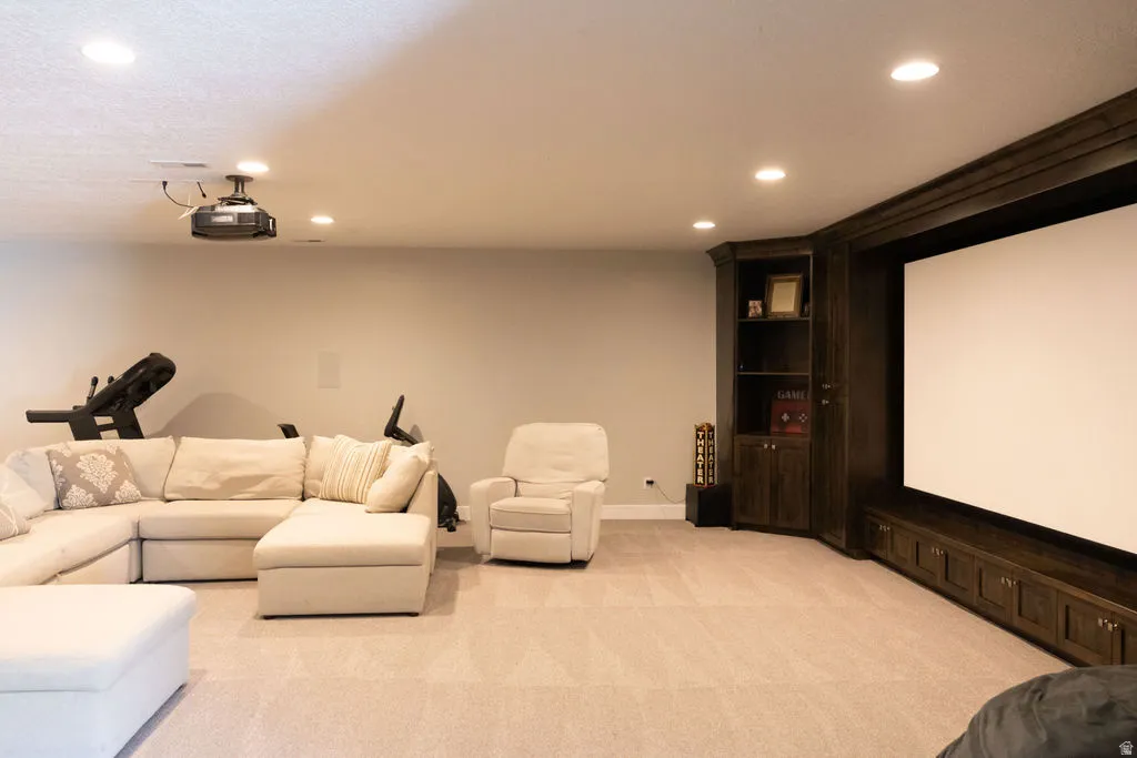 Recessed lighting, ceiling-mounted projector, built-in display screen, custom dark wood cabinetry, and built-in storage
