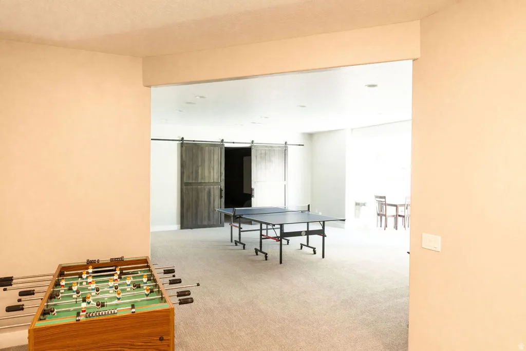 Open concept bonus room with light-toned carpeting and recessed lighting