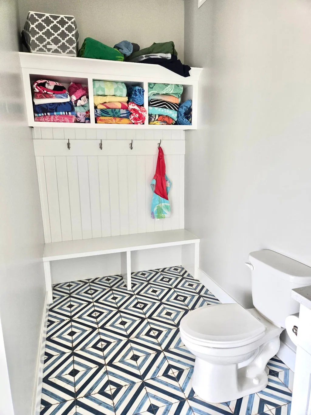 White built-in bench with integrated storage and coat hooks