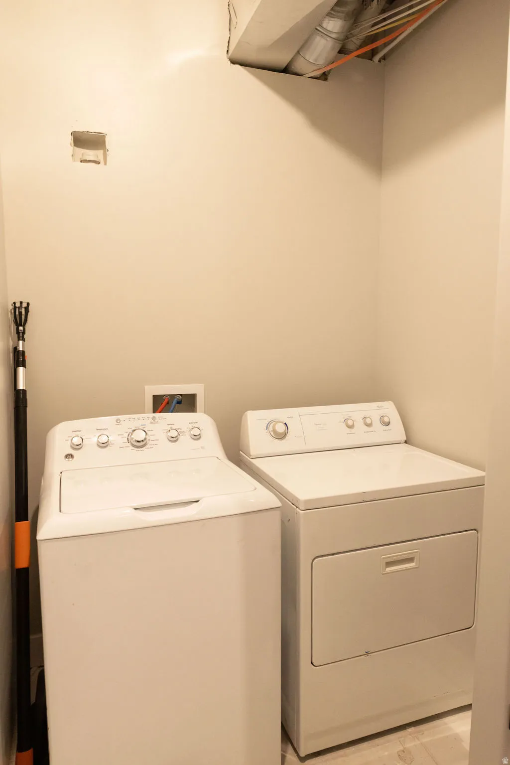Dedicated laundry area with a white top-load washer and a white front-load dryer
