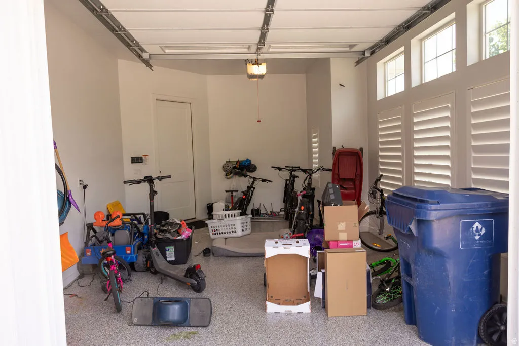 Garage with an epoxy-coated floor, overhead lighting fixture, and window shutters