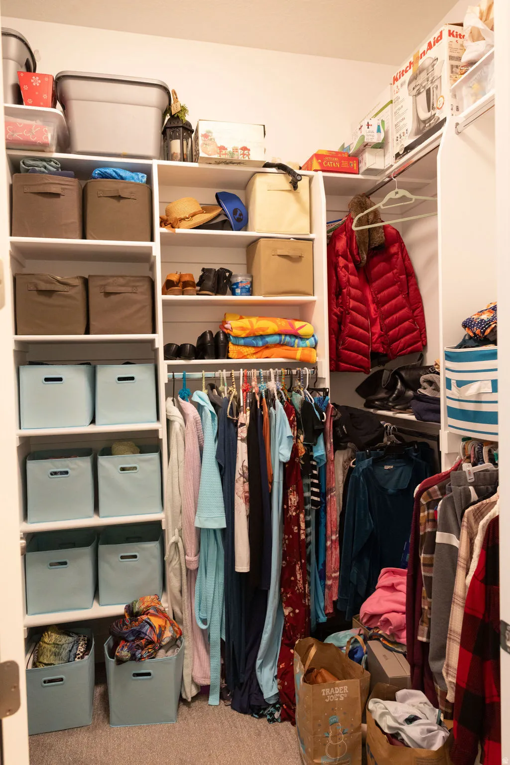 Custom closet system with white shelving, hanging rods, and built-in storage compartments