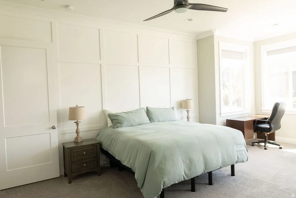 Wall paneling accent, recessed lighting, ceiling fan, multiple windows with blinds, and neutral carpet flooring