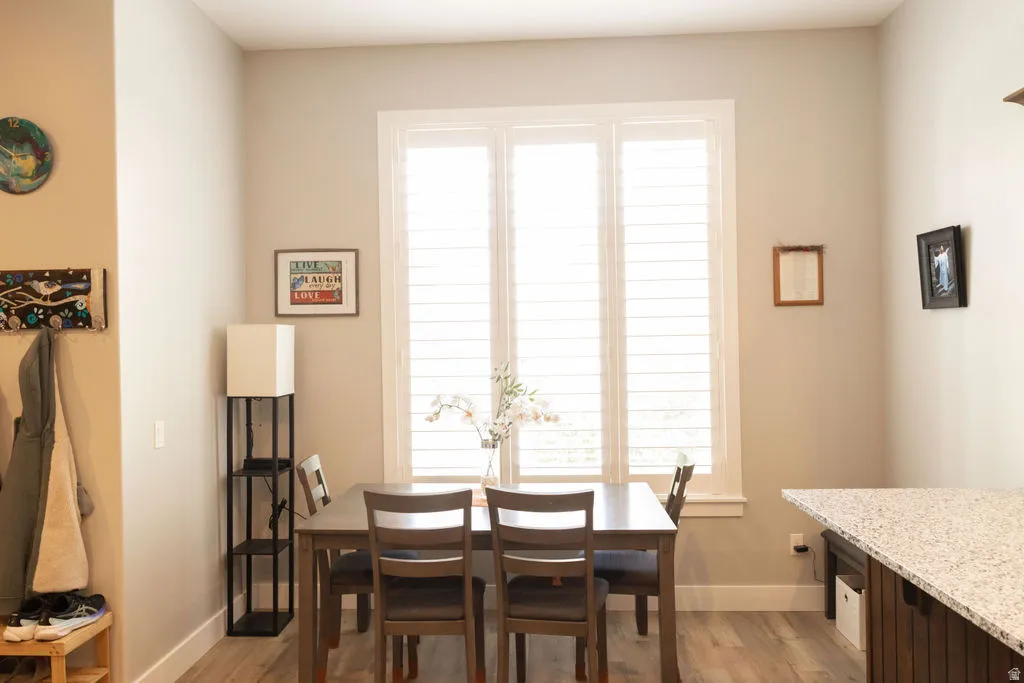 Wood-finish flooring, white window shutters, and a built-in counter with a speckled surface