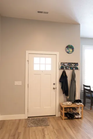 Entryway featuring a white door with upper window panes, wood-finish flooring, and white trim