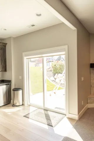 Sliding glass door, recessed lighting, wood-finish flooring, stone fireplace surround, dark wood cabinetry