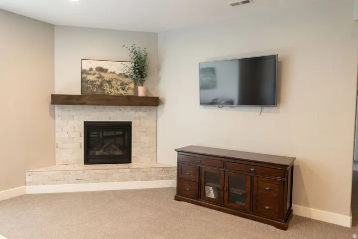 Corner fireplace featuring a tile surround and wood mantel