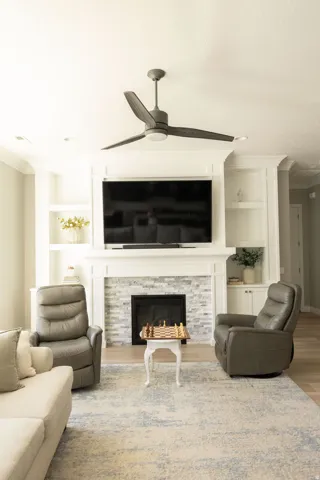 Fireplace with a stone tile surround, integrated hearth, and a white mantel