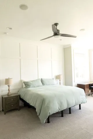 Recessed ceiling lighting, ceiling fan with integrated light, paneled accent wall, neutral carpet flooring, and a window with blinds