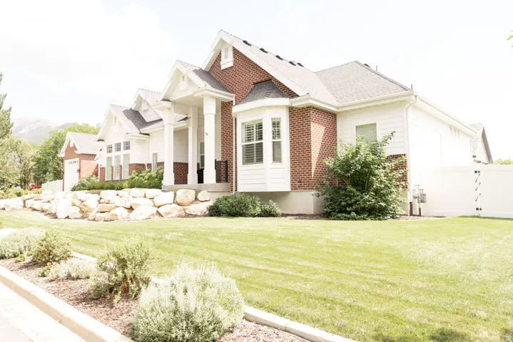 Brick and siding exterior with a covered porch, bay window, and gabled rooflines