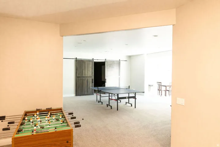 Open concept bonus room with light-toned carpeting and recessed lighting