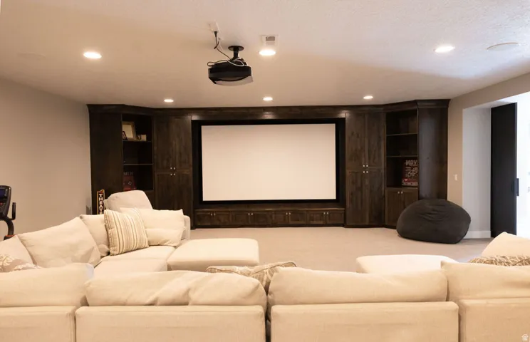 Built-in media center with projection screen, recessed lighting, ceiling-mounted projector, and integrated cabinetry