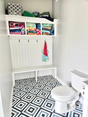 White built-in bench with integrated storage and coat hooks